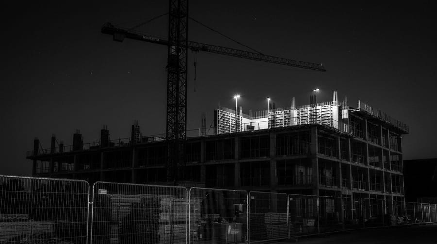 Tower crane above a partially built concrete structure at night